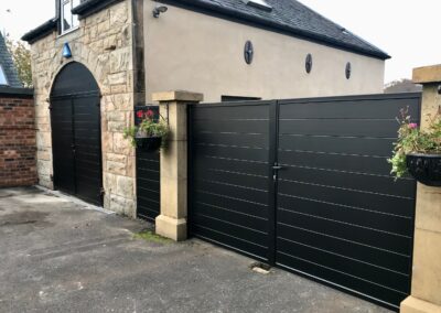 AES (SCOTLAND) LTD recently installed aluminium garage doors to match previously installed driveway gates in RAL9005 - Jet Black.