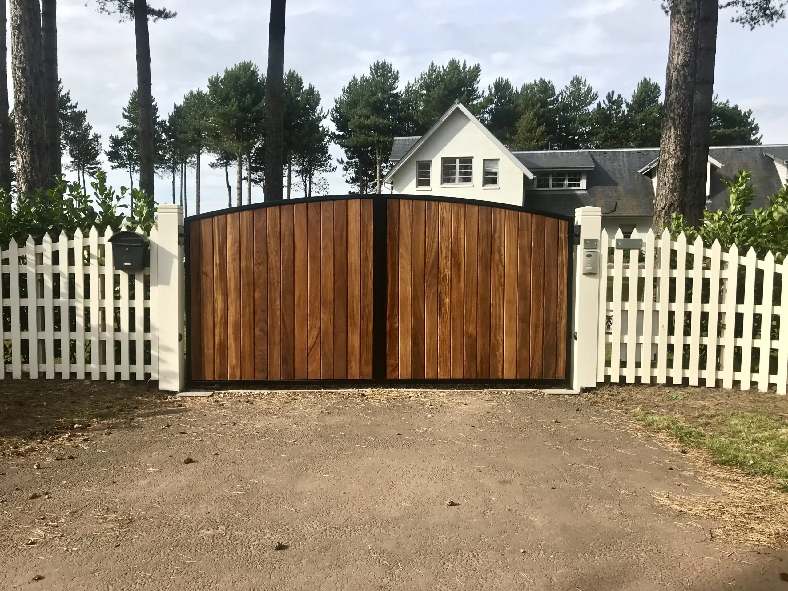 Automatic metal framed gates clad with stained iroko timber installed in Scotland 