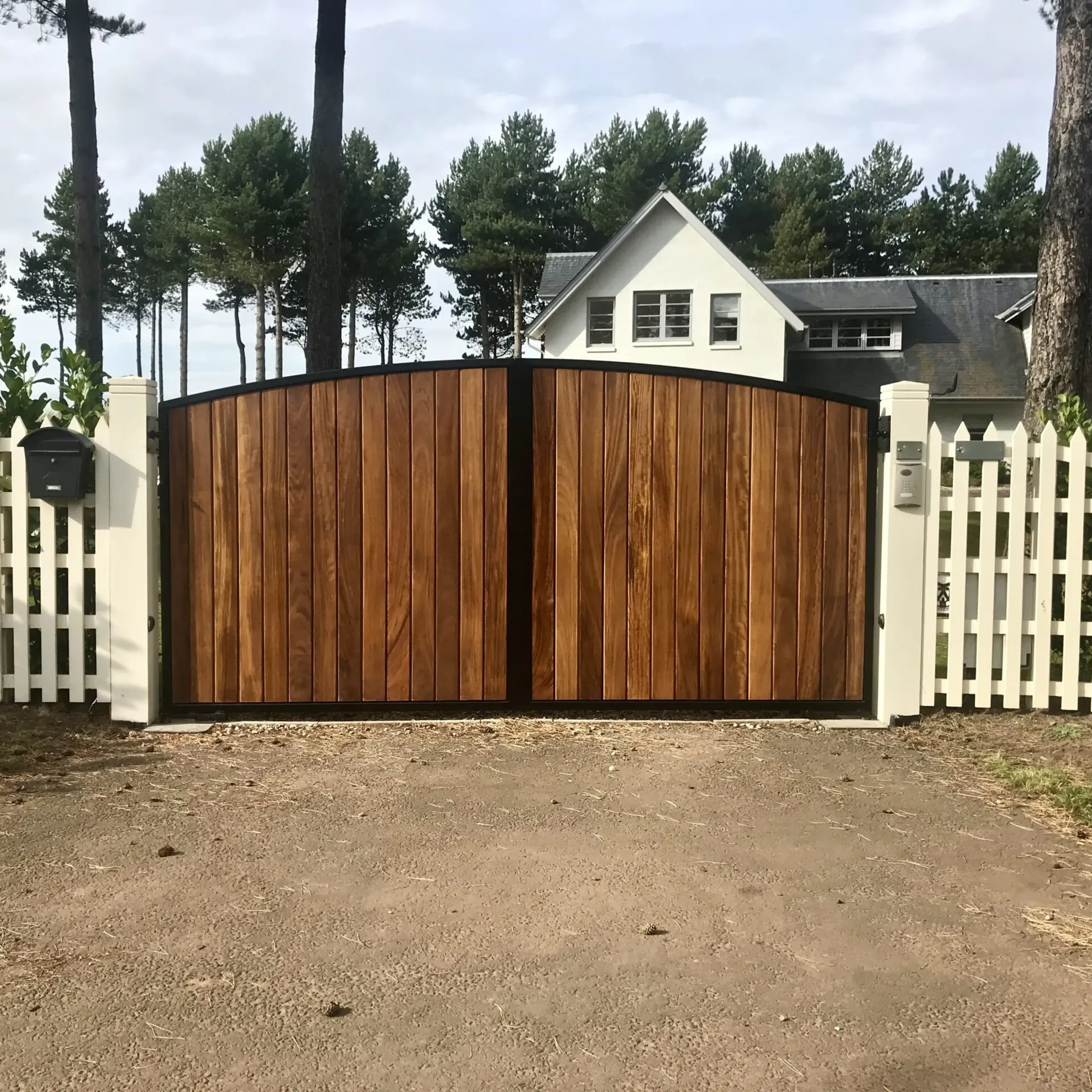 Automatic metal framed gates clad with stained iroko timber installed in Scotland 