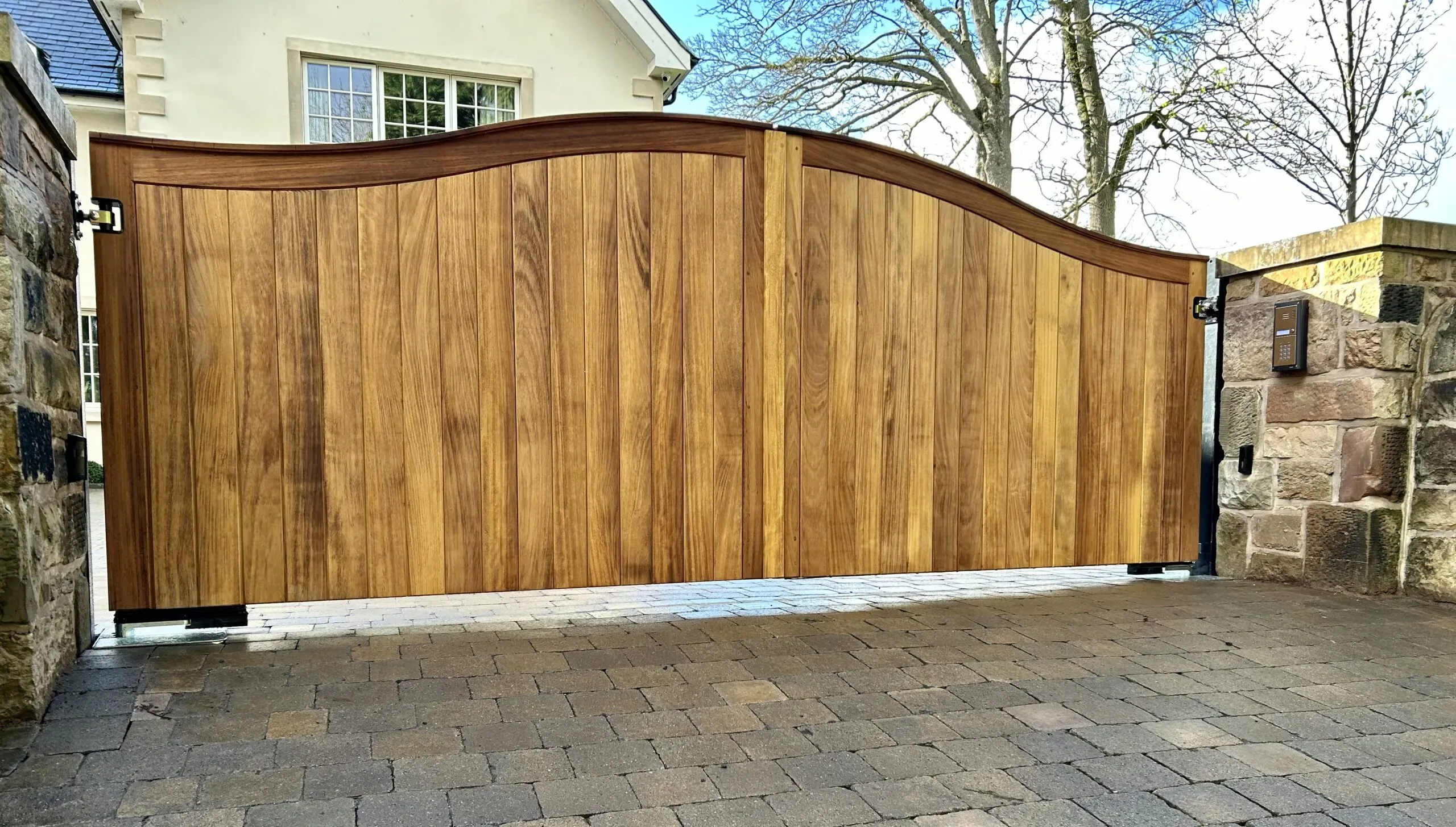 A pair of solid iroko wooden electric gates with underground operators installed in Edinburgh