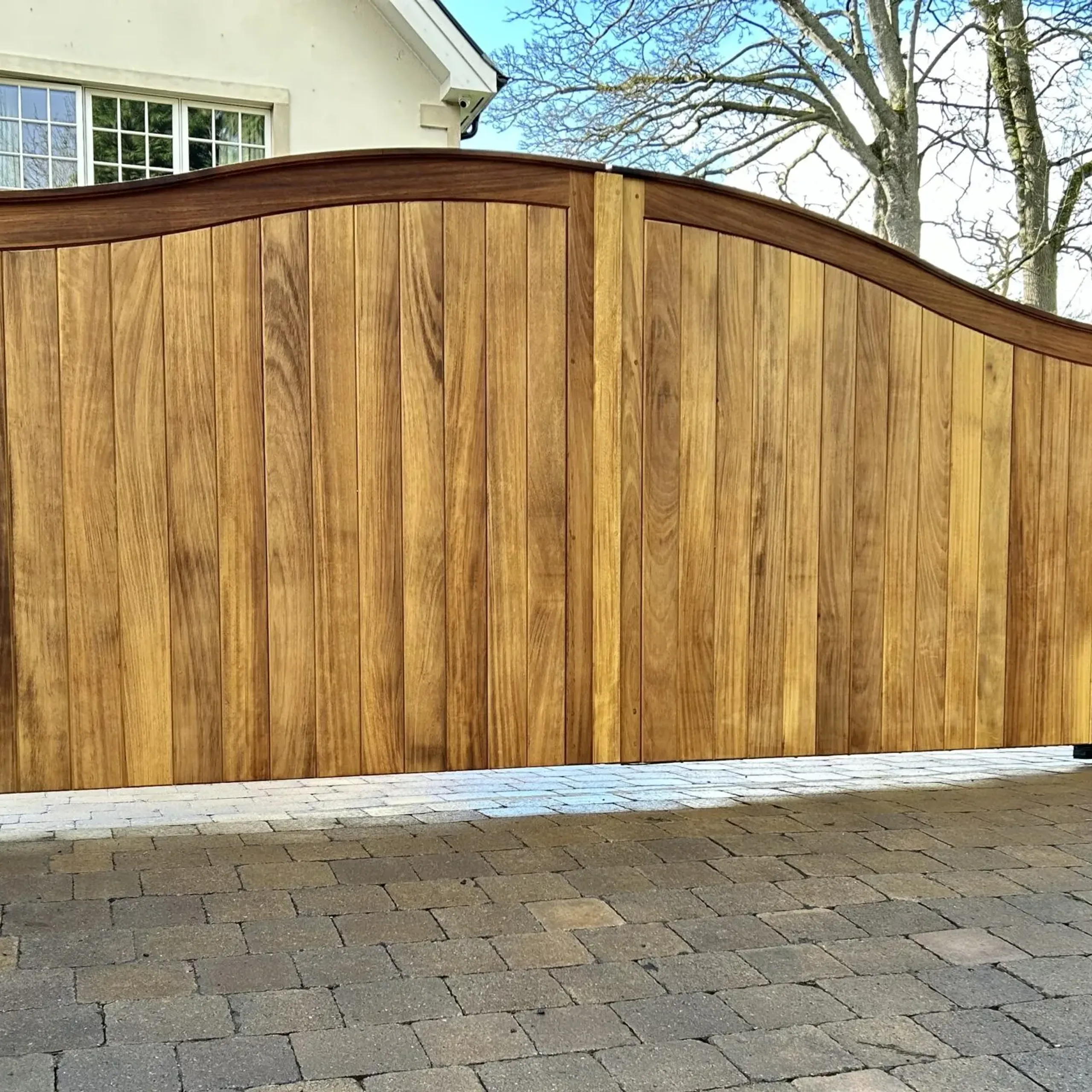 A pair of solid iroko wooden electric gates with underground operators installed in Edinburgh