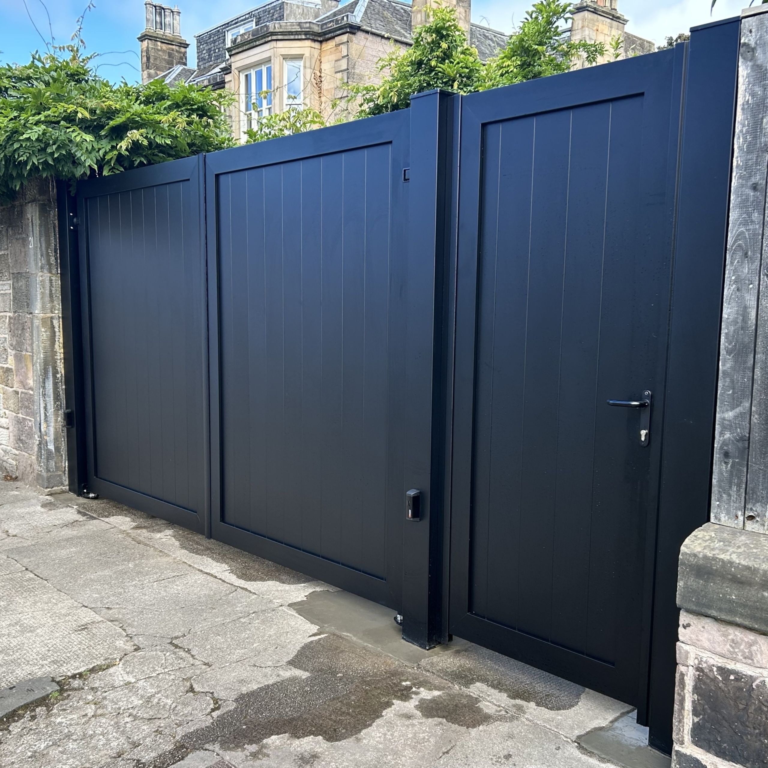 Black electric aluminium gates with matching pedestrian gate installed in Edinburgh.